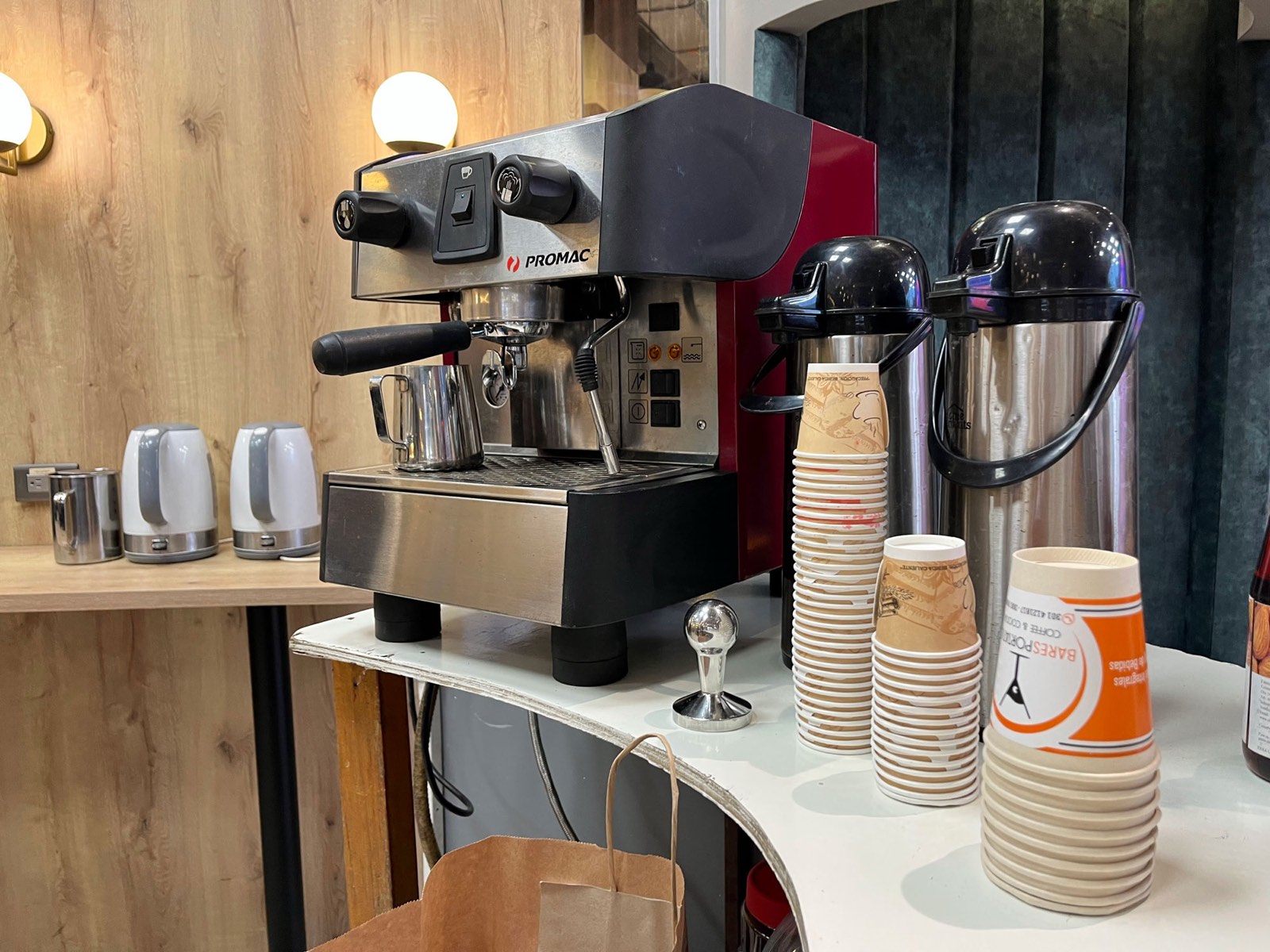 Máquina de espresso profesional, termos y vasos listos en una estación de café para un evento corporativo