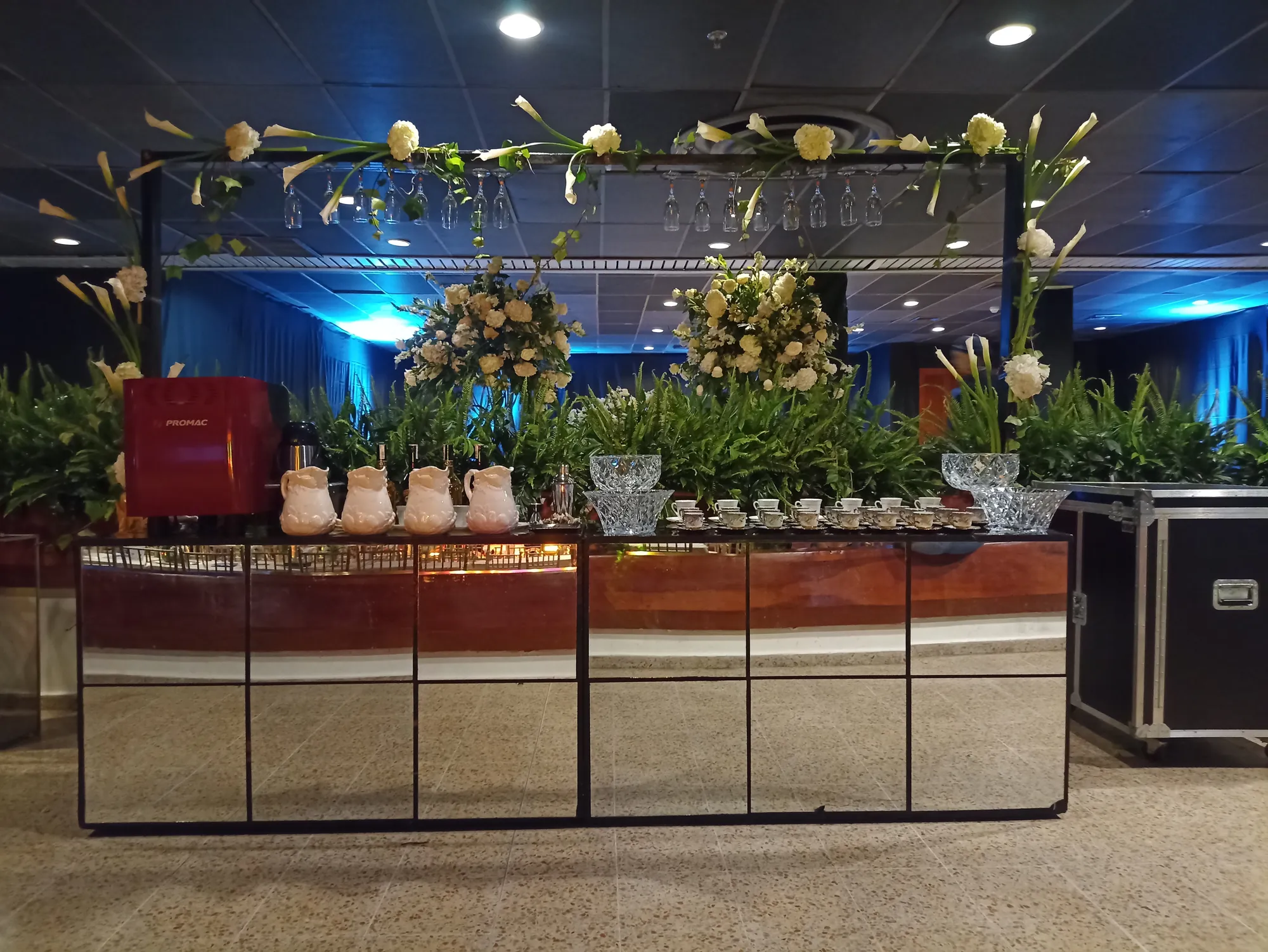 Barra de café y coctelería ambientada con flores blancas, cristalería y máquina de espresso en una gala