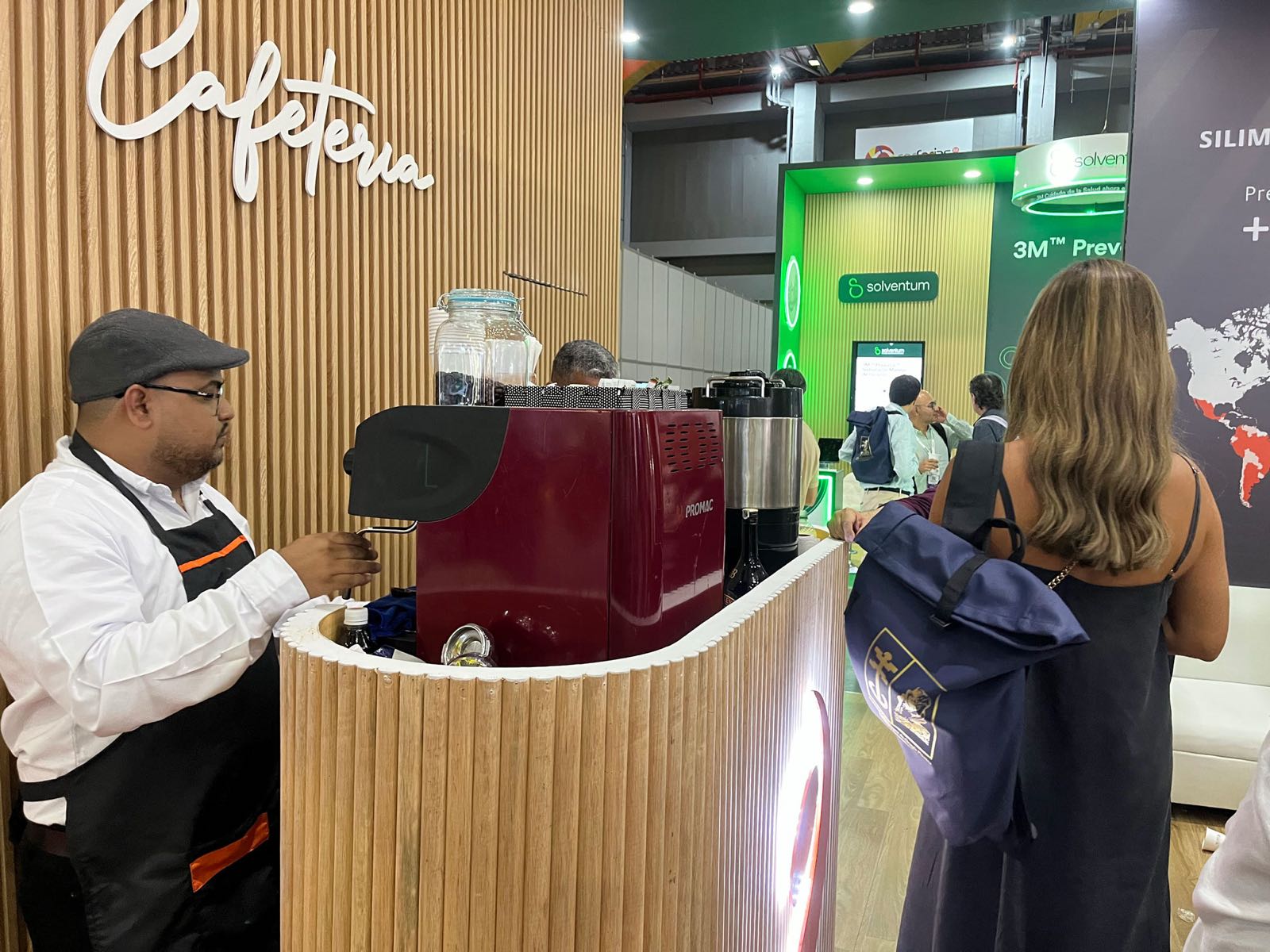 Barista de Experiencia VINTO preparando espresso mientras una asistente espera su bebida en un congreso en Barranquilla