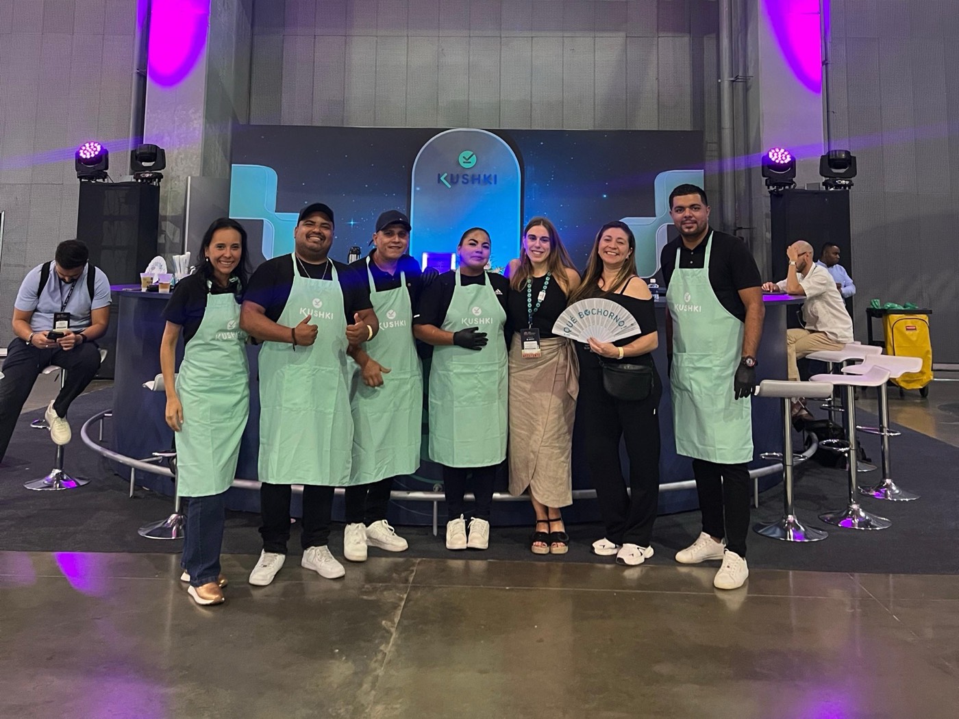 Equipo de baristas y bartenders con delantales personalizados con la marca del cliente en un evento corporativo